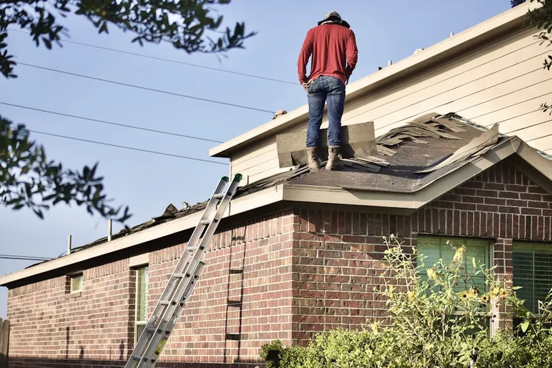 Professional roofer working on a residential roof in Greens Farms
